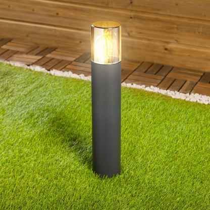 high-quality frontal image of bluebell’s dark grey outdoor medium post light switched on using amber lighting on a grey background