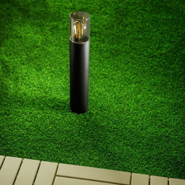 This post light features a smoky diffuser, and measures 50 cm high. With its reduced appearance due to its height and colour, this elegant pillar light suits both modern and traditional architecture.