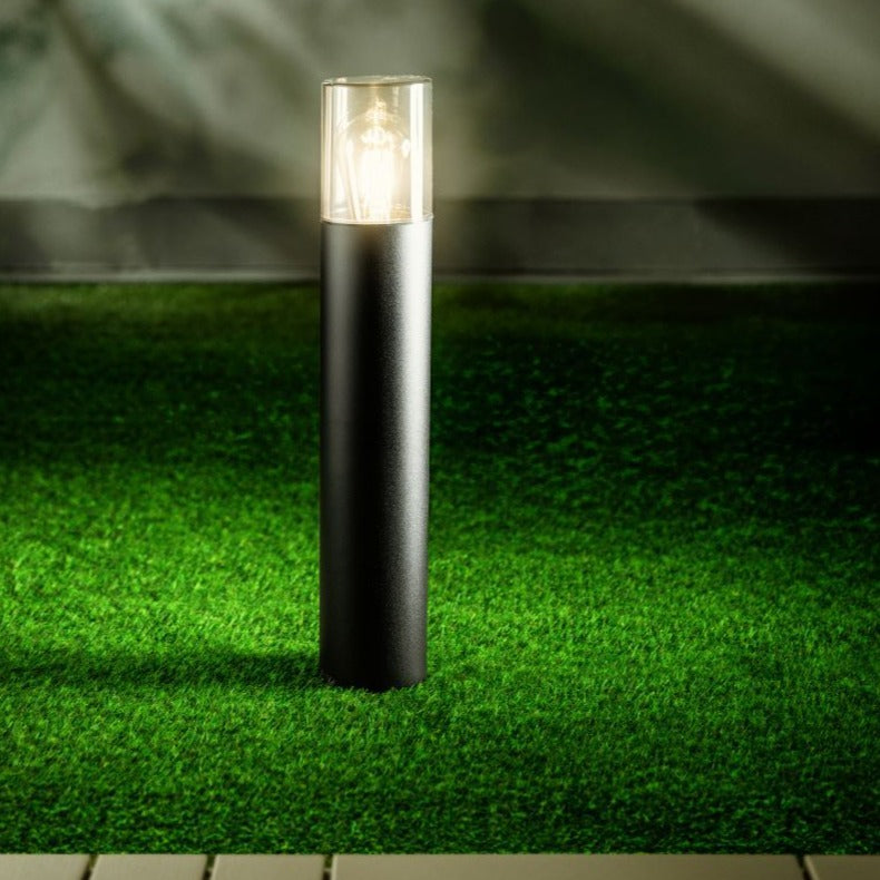 This post light features a smoky diffuser, and measures 50 cm high. With its reduced appearance due to its height and colour, this elegant pillar light suits both modern and traditional architecture.