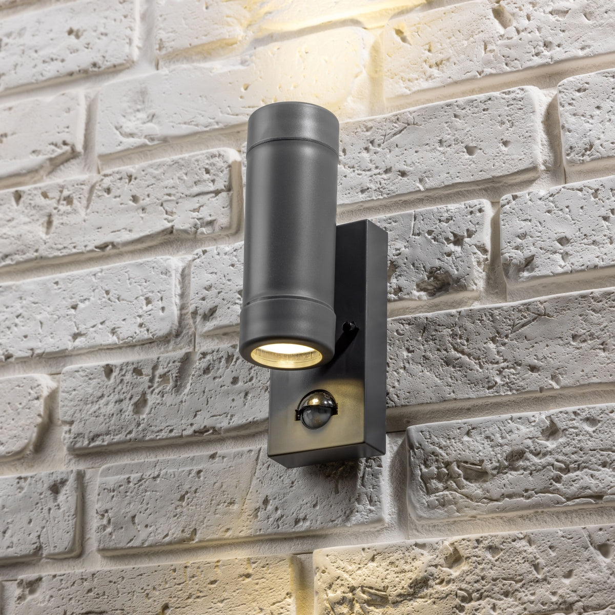 Our Valentine dark grey outdoor wall mounted up and down cylinder outdoor light with motion sensor would look perfect in a modern or more traditional home design. Outside wall lights can provide atmospheric light in your garden, at the front door or on the terrace as well as a great security solution. It is designed for durability and longevity with its robust material producing a fully weatherproof and water resistant light fitting.