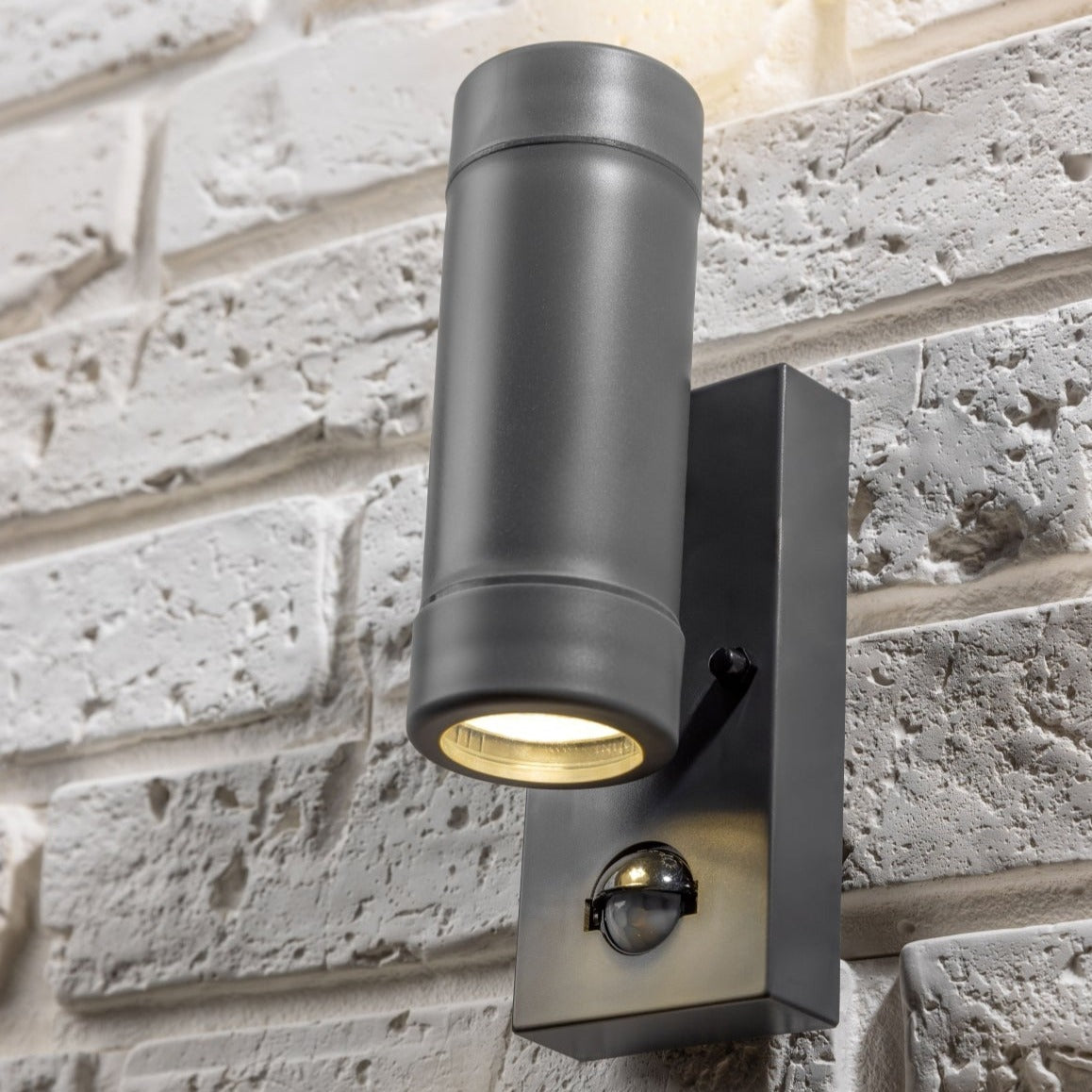 Our Valentine dark grey outdoor wall mounted up and down cylinder outdoor light with motion sensor would look perfect in a modern or more traditional home design. Outside wall lights can provide atmospheric light in your garden, at the front door or on the terrace as well as a great security solution. It is designed for durability and longevity with its robust material producing a fully weatherproof and water resistant light fitting.