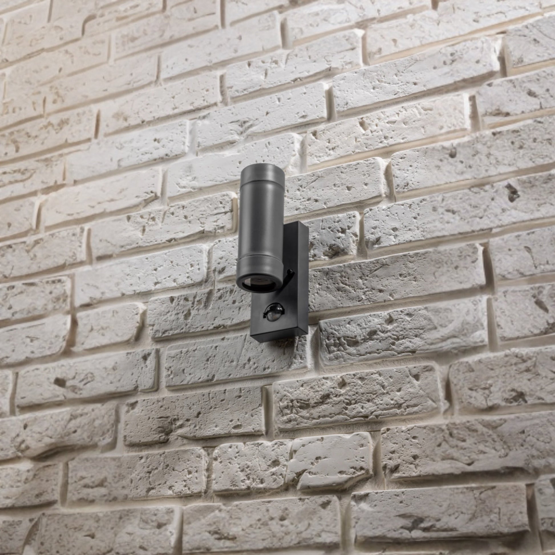 Our Valentine dark grey outdoor wall mounted up and down cylinder outdoor light with motion sensor would look perfect in a modern or more traditional home design. Outside wall lights can provide atmospheric light in your garden, at the front door or on the terrace as well as a great security solution. It is designed for durability and longevity with its robust material producing a fully weatherproof and water resistant light fitting.