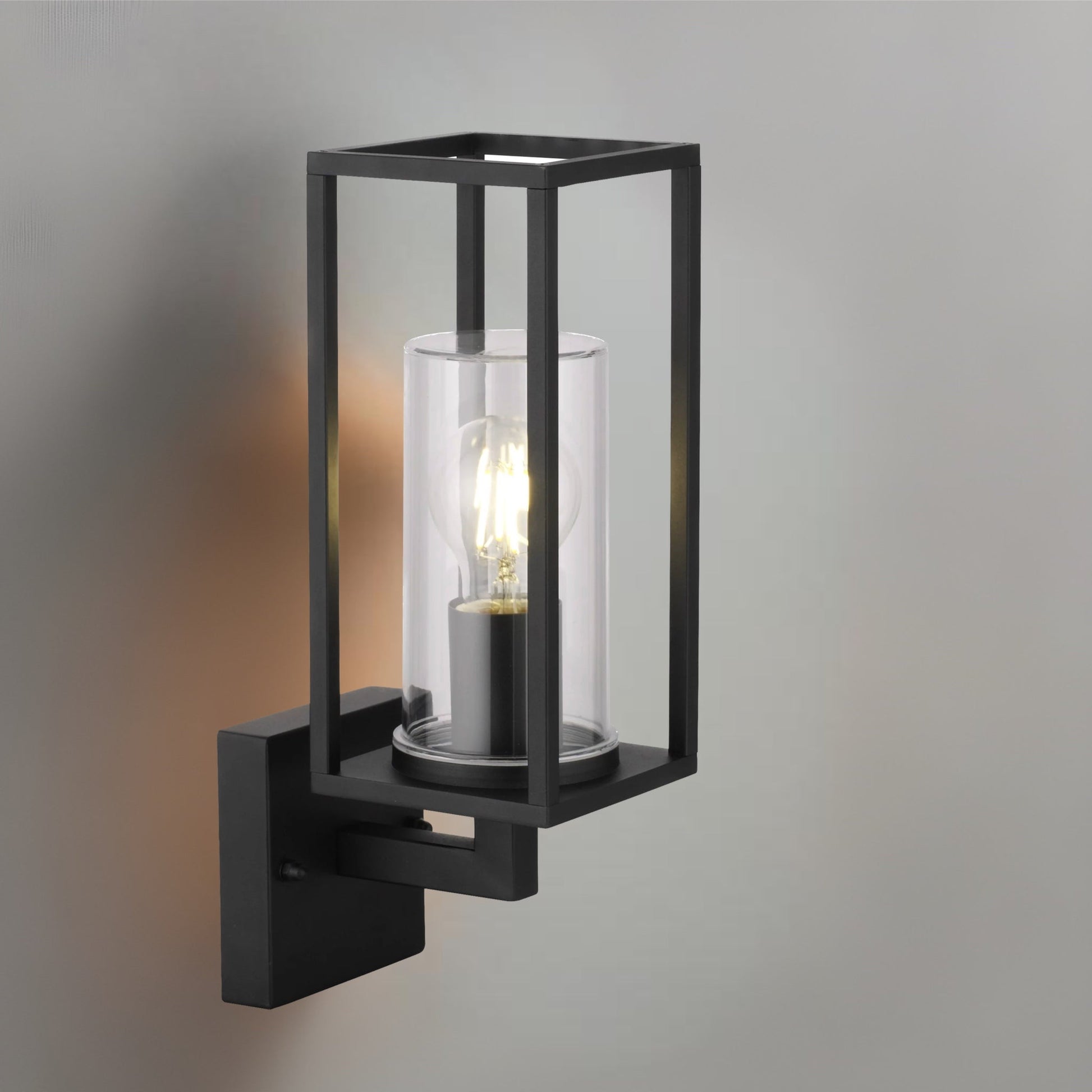 Wall lantern with clear glass and black finish. The elegant appearance of the lamp makes it ideal for modern outdoor spaces. You can install it with a decorative light bulb to give a more traditional look to a contemporary design.