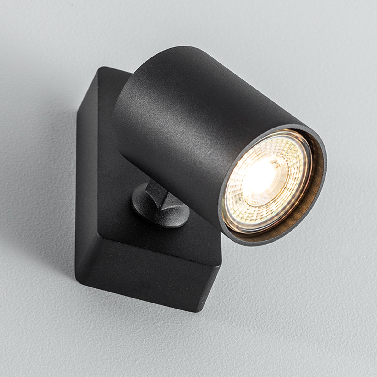 The black Nell lamp consists of a cylindrical spotlight, which can be tilted and adjusted on its own axis. The spotlight is attached to a rectangular bracket, which makes it equally suitable for mounting on walls and ceilings. Made of an aluminium body and powder coated black, the lamp with its simple design fits well into different spaces. Whether functional office or cosy home - the timeless lamp is an perfect for many types of use.